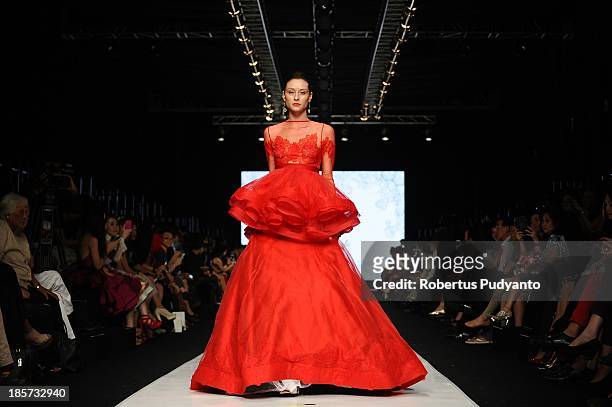Model showcases designs by Joko Wiyanto on the runway at the Mazda Young Vibrant Designer show during Jakarta Fashion Week 2014 at Senayan City on...
