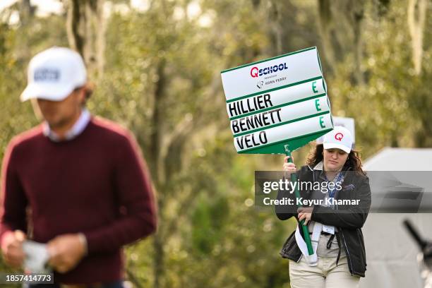 Volunteer standard-bearer walks with a group during the first round of the PGA TOUR Q-School presented by Korn Ferry tournament on the Dye's Valley...