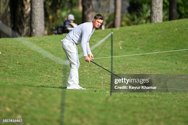 William Mouw moves the rope line before playing his shot from the 10th hole rough during the first round of the PGA TOUR Q-School presented by Korn...