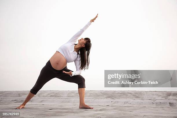 pregnant woman in yoga lunging pose - prenatal yoga stock pictures, royalty-free photos & images