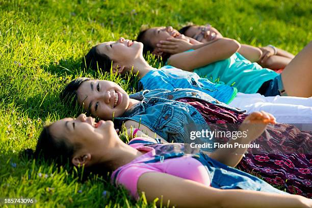 girls lying on grass - happy tween girls lying on grass stock pictures, royalty-free photos & images