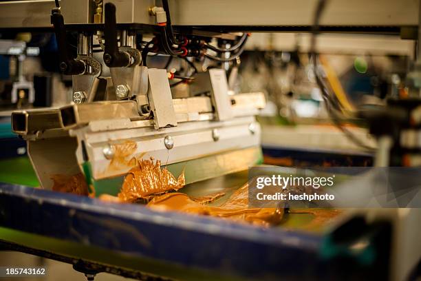 screen print machine spreading ink on frame - silk screen stock pictures, royalty-free photos & images