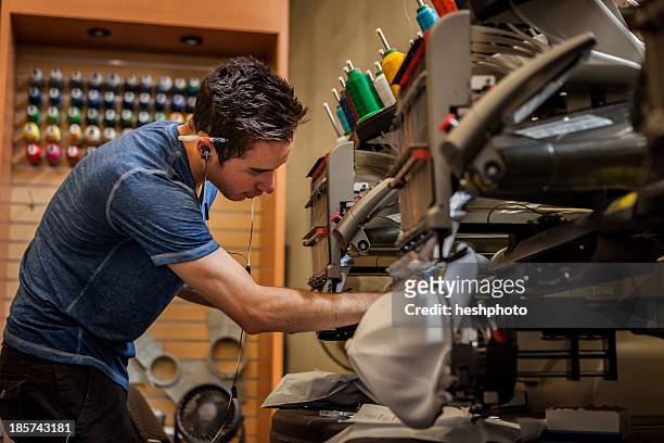 worker preparing embroidery machine in t-shirt  printing workshop - tee reel stock pictures, royalty-free photos & images