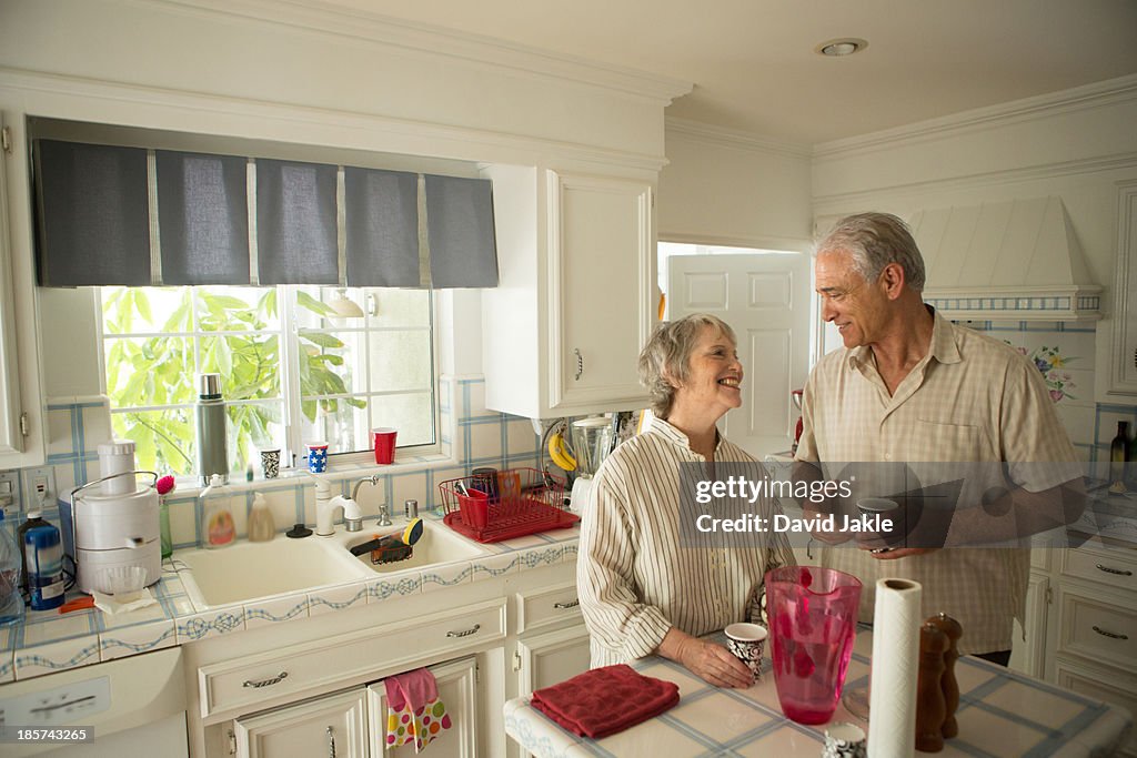 Senior couple in kitchen,  smiling