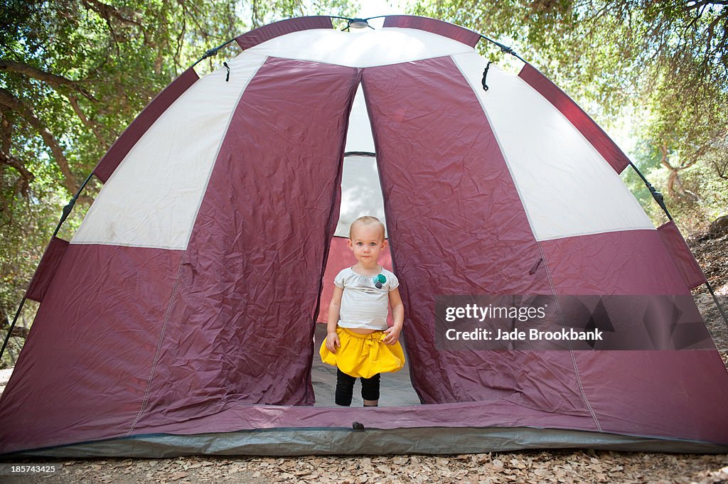 Young female toddler in tent doorway