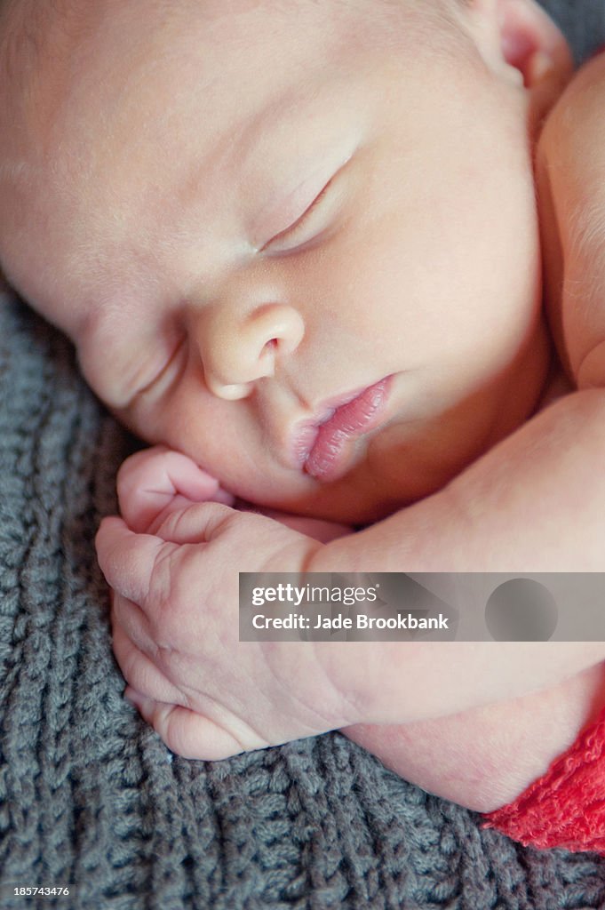 Baby boy lying on grey blanket,  sleeping