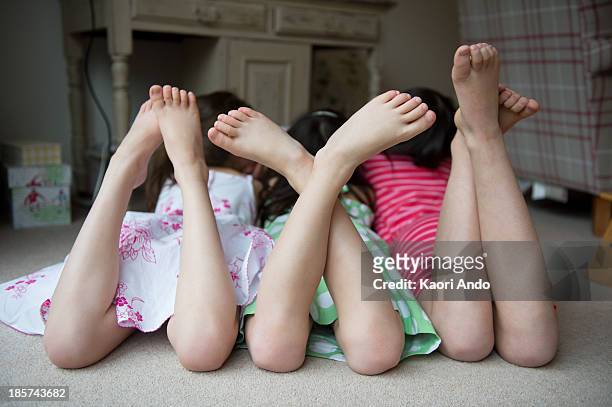 girls lying on floor together with feet up - barefoot feet up lying down girl stockfoto's en -beelden