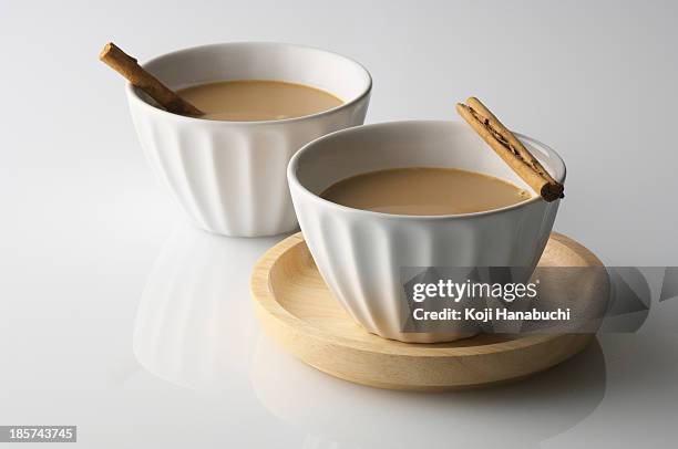 still life of two bowls of drink with cinnamon sticks - chai stockfoto's en -beelden