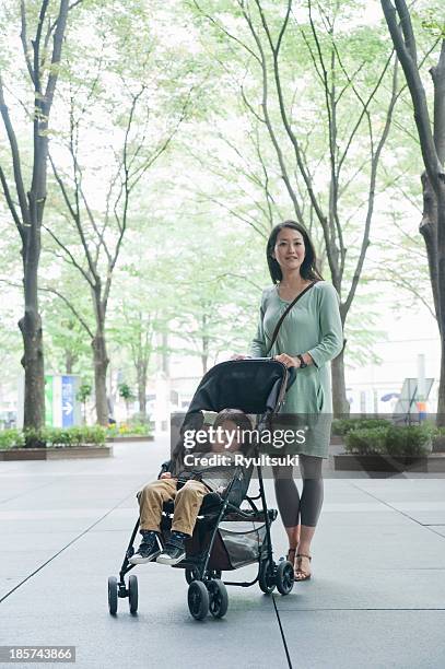 mother with son sitting in stroller,  portrait - ベビーカー ストックフォトと画像