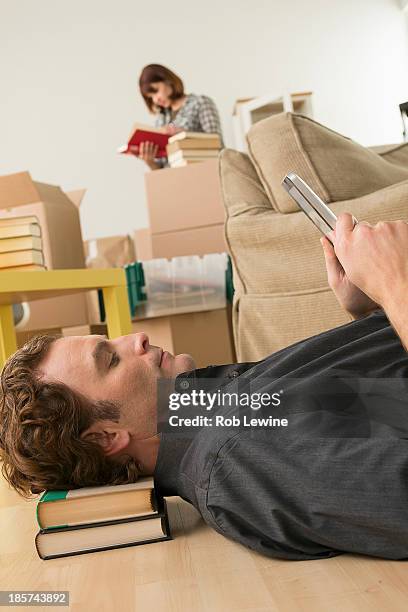 man lying on floor looking at digital tablet whilst moving - head rest stock pictures, royalty-free photos & images
