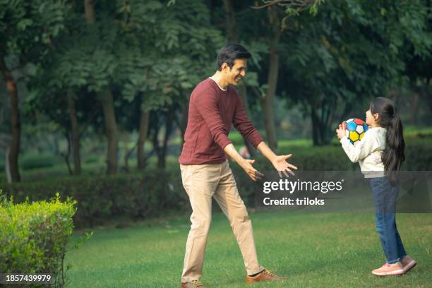 father and daughter enjoying with ball in garden - hurling stock pictures, royalty-free photos & images