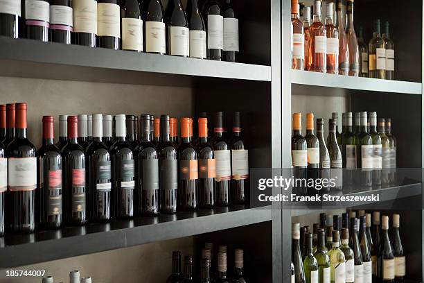wine bottles on shelves - wine bar foto e immagini stock