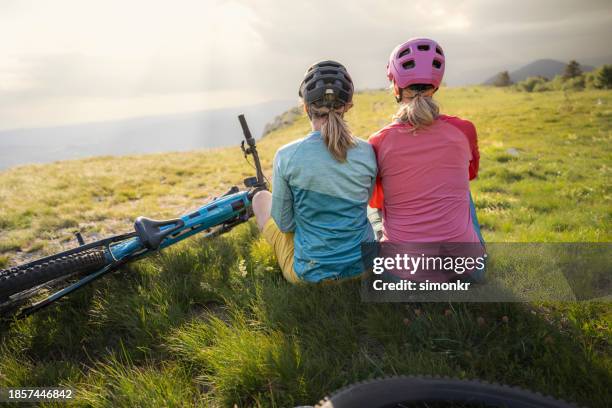 mountain bikers sitting on mountain top - pink hard hat stock pictures, royalty-free photos & images