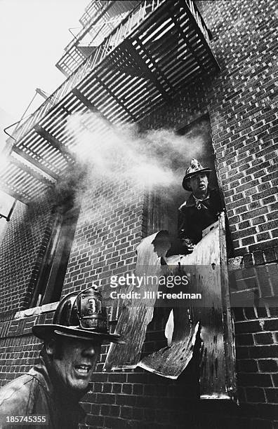 Firemen attend to a fire in a building in the South Bronx, New York City, 1976.