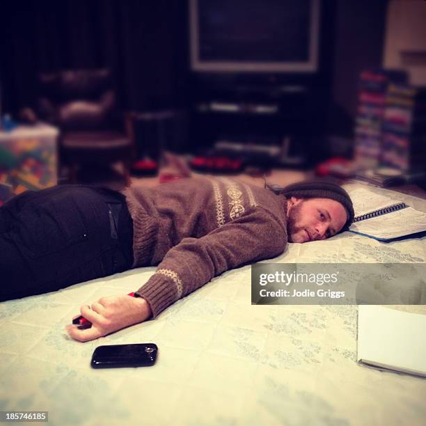 tired man laying on his stomach on the floor - allongé sur le devant photos et images de collection