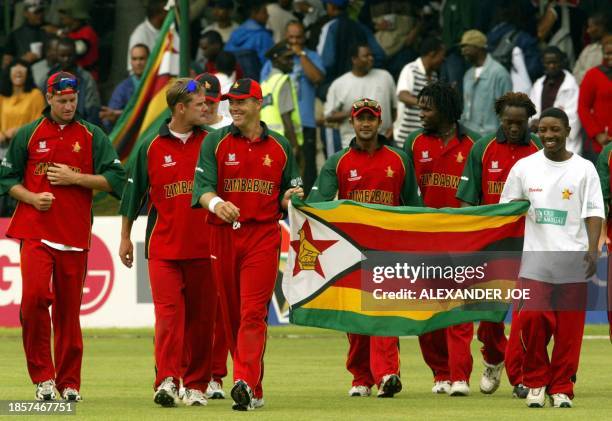 An overjoyed Zimbabwean cricket team parade the country flag in Bulawayo 04 March 2003 after qualifying for the Cricket World Cup 2003 super six when...