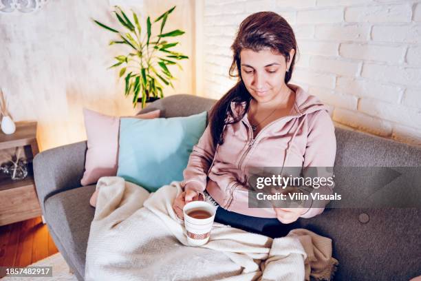 woman with flu checking temperature - physical weakness stock pictures, royalty-free photos & images