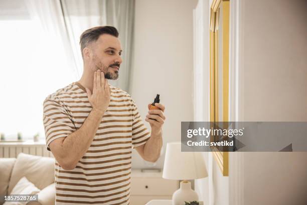 morning routine - man applying perfume stock pictures, royalty-free photos & images
