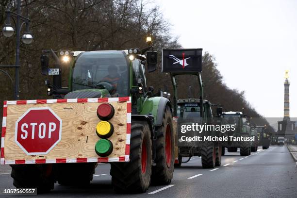 Farmers arrive on their tractors at the Brandenburg Gate to protest against planned cuts to state subsidies that bring down their fuel costs on...