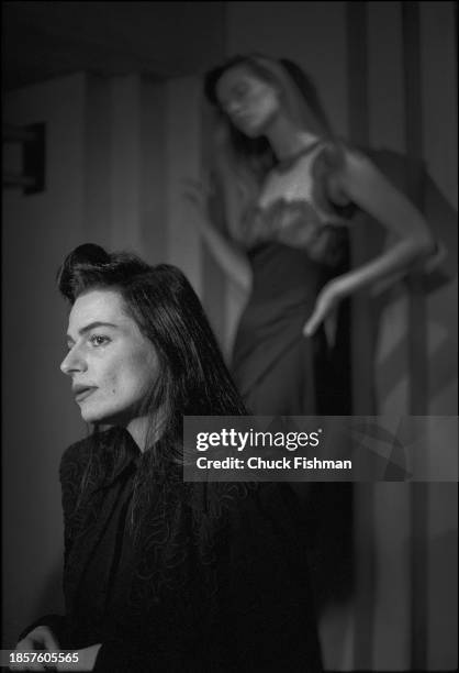 Profile of American fashion designer Norma Kamali during one of her Fashion Week shows, New York, New York, November 1987. An unidentified model is...