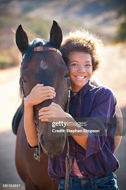 "tween" girl hugging her horse - black horse stockfoto's en -beelden