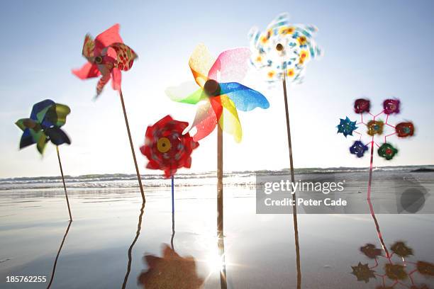 windmills in the sand at the waters edge - paper windmill stock pictures, royalty-free photos & images