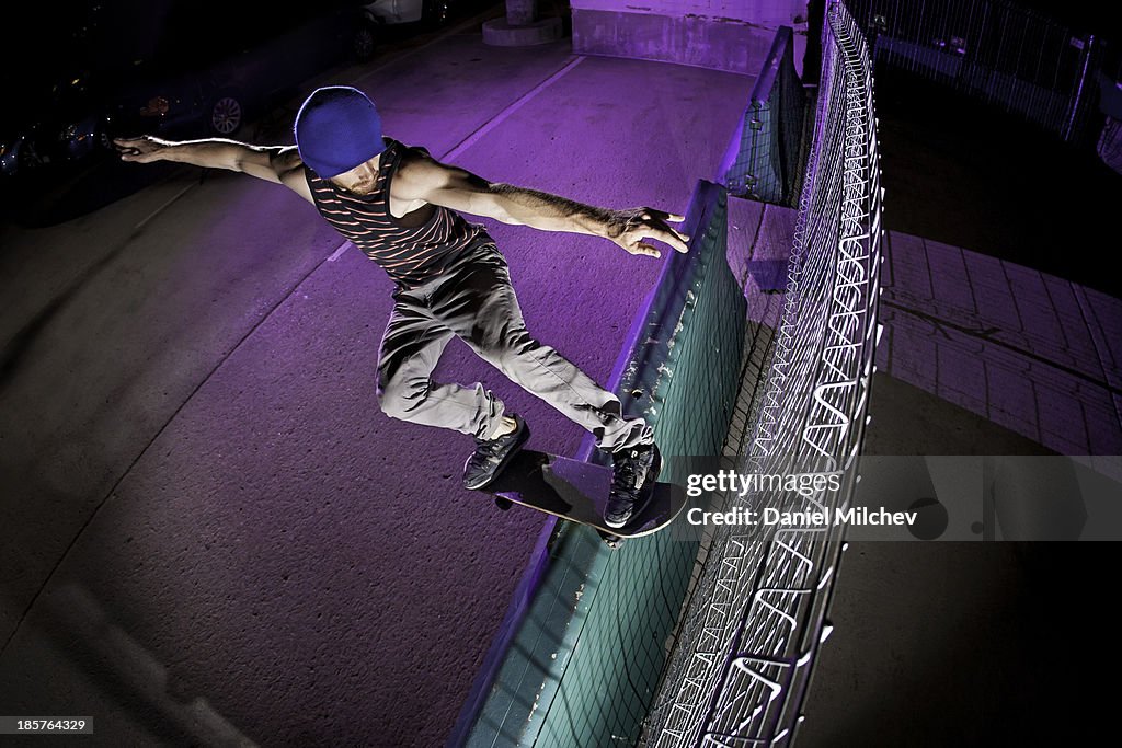 Skateboarder doing a trick on a jersey barrier.