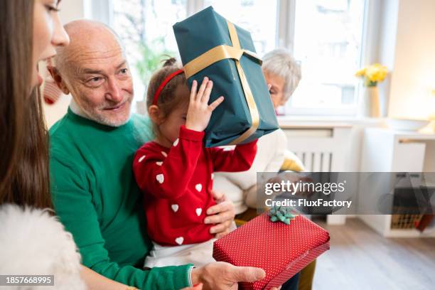 multi-generational family exchanging christmas presents - multi generational family with pet stock pictures, royalty-free photos & images
