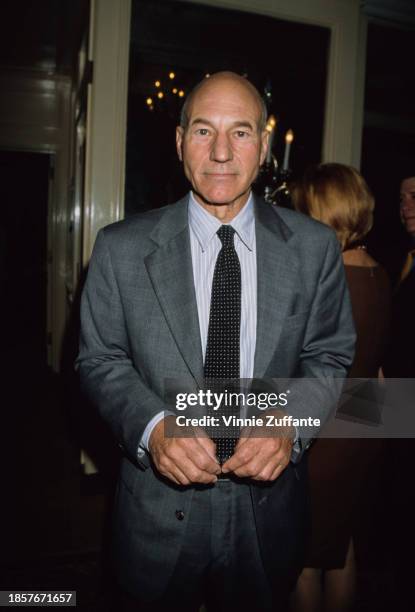 British actor Patrick Stewart, wearing a grey suit over a blue-and-white striped shirt with a spotted tie, attends the 5th Annual Women in Film Lucy...