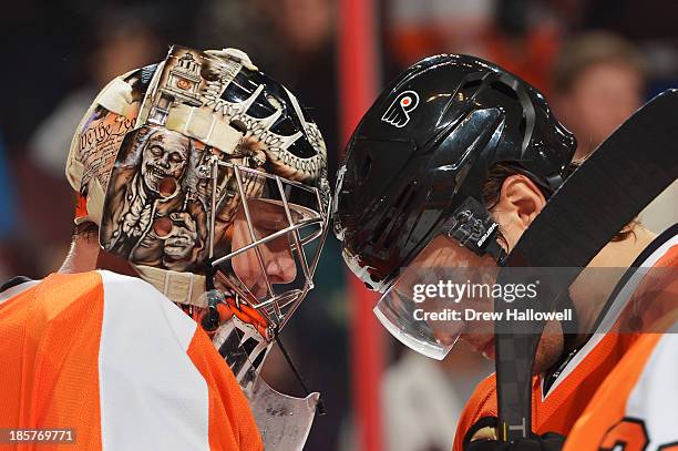 Steve Mason and Luke Schenn of the Philadelphia Flyers bump heads after a 2-1 win over the New York Rangers at the Wells Fargo Center on October 24,...