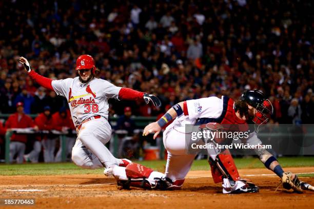 Pete Kozma of the St. Louis Cardinals scores in the seventh inning as Jarrod Saltalamacchia of the Boston Red Sox loses the ball during Game Two of...