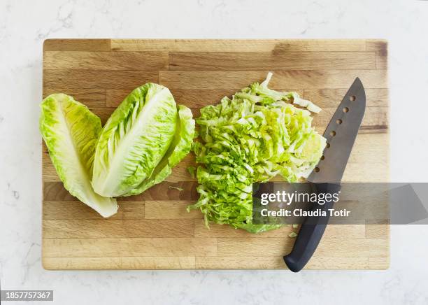 chopped romaine lettuce on wooden cutting board - romaine lettuce stock pictures, royalty-free photos & images