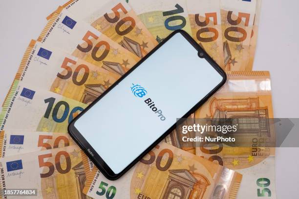 The BitoPro logo is being displayed on a smartphone screen that is placed on 50 and 100 Euro bills in Athens, Greece, on December 18, 2023.