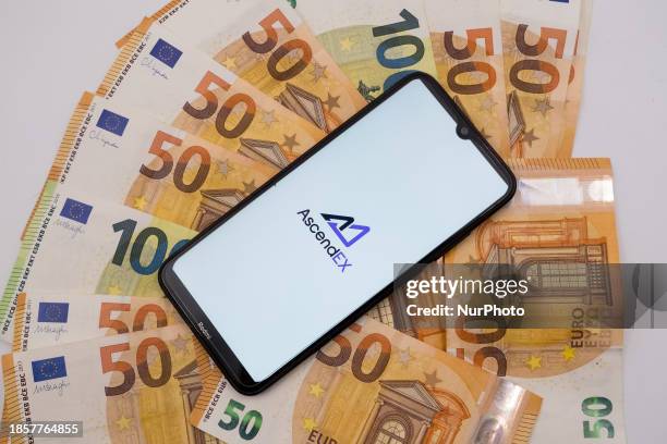 The AscendEX logo is being displayed on a smartphone screen that is placed on 50 and 100 Euro bills in Athens, Greece, on December 18, 2023.