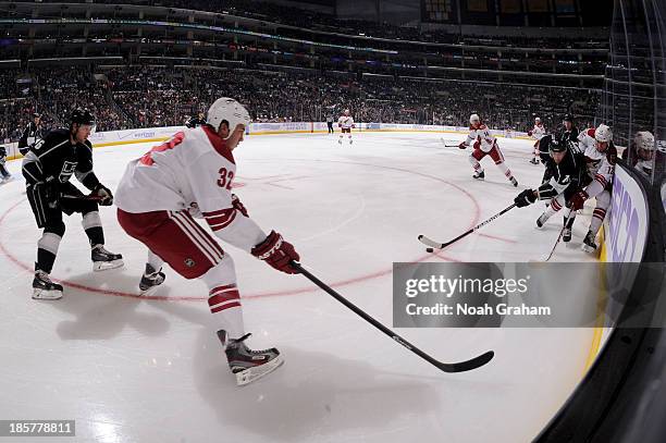 Jordan Nolan of the Los Angeles Kings skates with the puck against Paul Bissonnette and Brandon Yip of the Phoenix Coyotes at Staples Center on...
