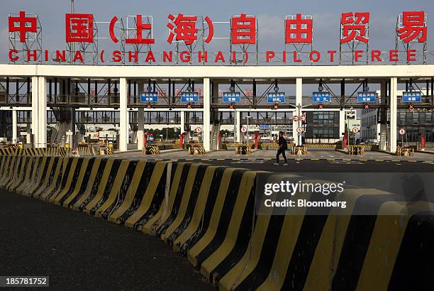 Man walks past the gate to China Pilot Free Trade Zone's Pudong free trade zone in Shanghai, China, on Thursday, Oct. 24, 2013. The area is a testing...