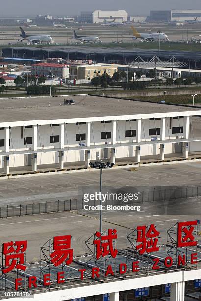 Cargo aircraft parked at Shanghai Pudong International Airport are seen behind a sign for China Pilot Free Trade Zone at the Pudong free trade zone...