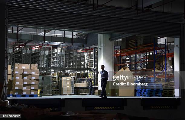 Worker walks in front of a storage area in a logistics center at China Pilot Free Trade Zone's Pudong free trade zone in Shanghai, China, on...