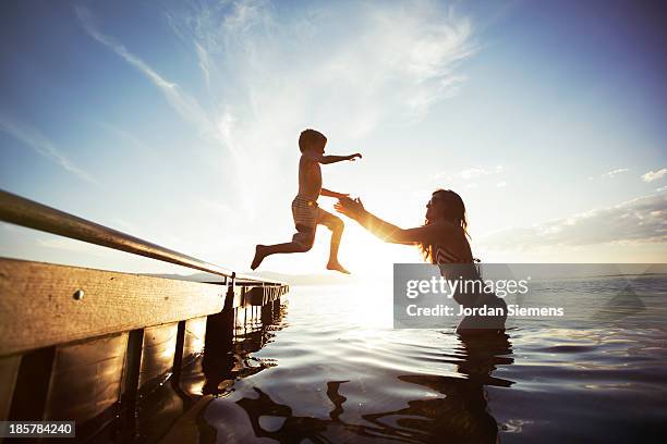 swimming in a lake. - family in silhouette stock pictures, royalty-free photos & images