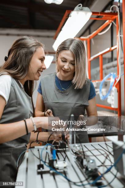 teamwork by female students operating programmable logic controller in classroom - programmable logic controller stock pictures, royalty-free photos & images