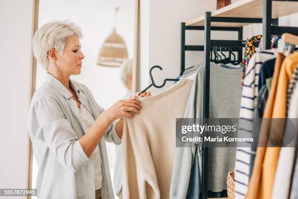 woman choosing dress in front of mirror. - railings stock pictures, royalty-free photos & images
