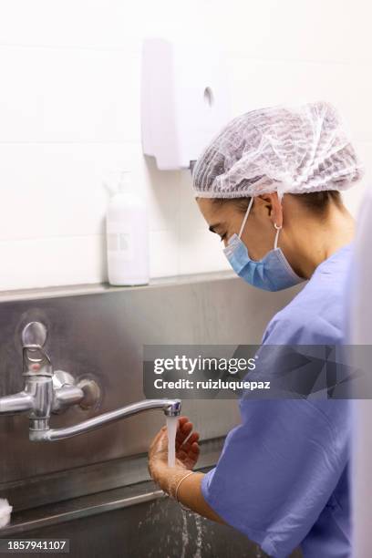 une chirurgienne se désinfecte les mains avant d’entrer dans la salle d’opération - buenos aires - argentine - se frotter les mains photos et images de collection