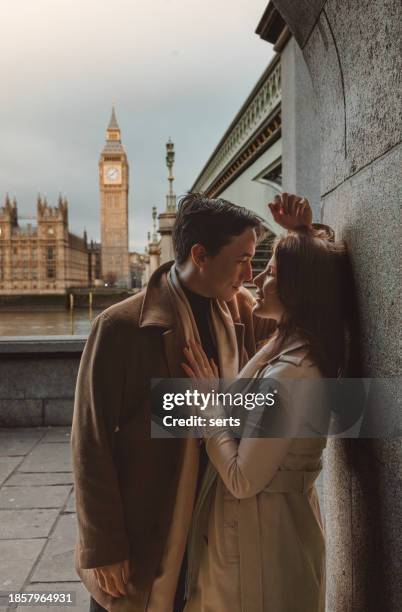 happy and young tourist couple kissing and enjoying a romantic getaway in iconic streets of london city against big ben, england, united kingdom - allegory stock pictures, royalty-free photos & images