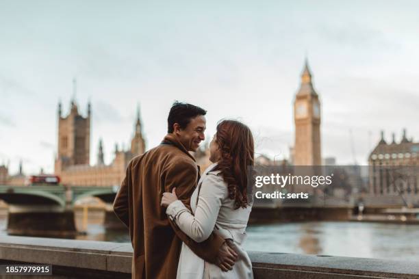 happy and young tourist couple enjoying a romantic getaway in iconic streets of london city, england, united kingdom - couple london stockfoto's en -beelden