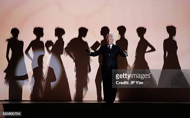 Designer Giorgio Armani acknowledges the audience after his runway show at the Giorgio Armani One Night Only NYC at Hudson's River Park SuperPier on...