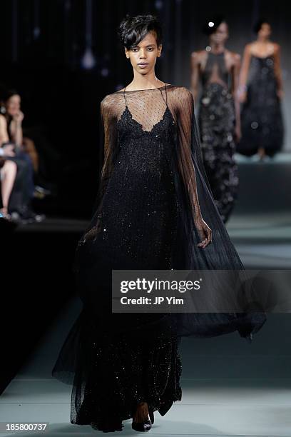 Model walks the runway at the Giorgio Armani One Night Only NYC at Hudson's River Park SuperPier on October 24, 2013 in New York City. Armani...