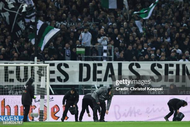 Volunteers pick up tennis balls from the pitch, used in a protest from fans, during the Bundesliga match between Borussia Mönchengladbach and SV...