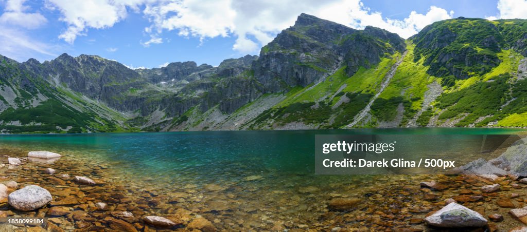 Scenic view of lake by mountains against sky