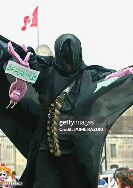An actor dressed in black passes in front of the Government Palace in Lima, Peru, 27 October 2000 during a protest against the government and...