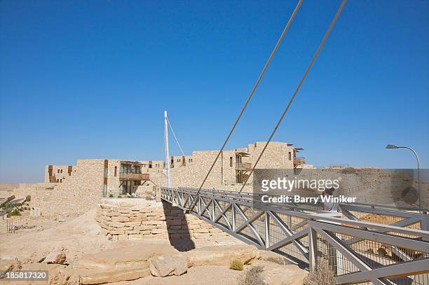 woman crossing suspension bridge in desert. - beresheet stock pictures, royalty-free photos & images